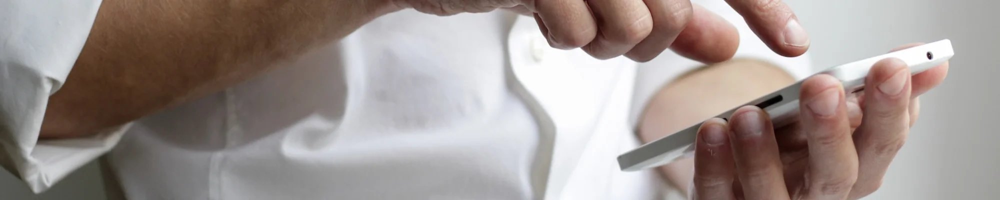 Person wearing a white shirt and using a mobile phone
